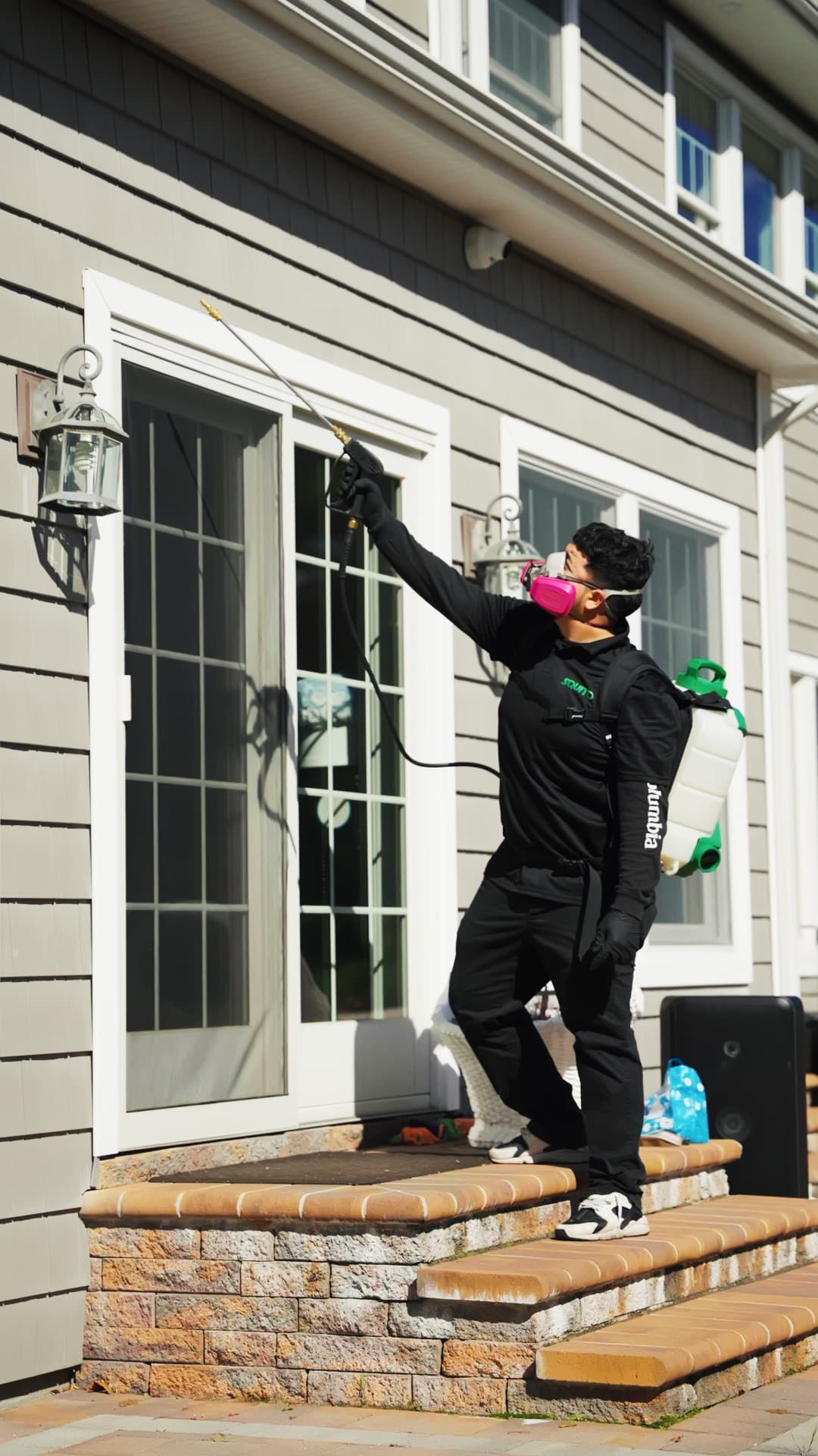 Squito technician treating a Long Island home exterior